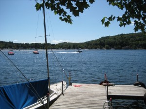 Empty dock with sailboat attached and lake in background