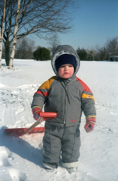 Michael Wyszomierski in a snowsuit holding a shovel