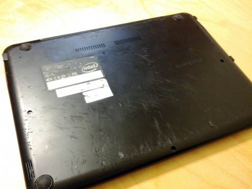 Bottom of a laptop with scratches.