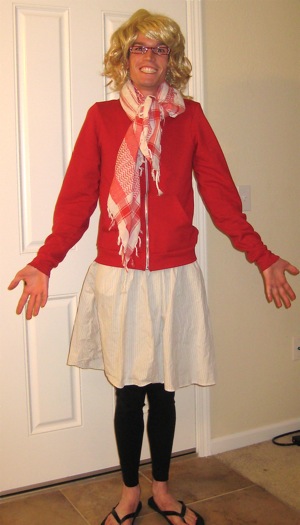 Wysz wearing a wig, red glasses, a red sweatshirt, a skirt, black leggins, and sandals
