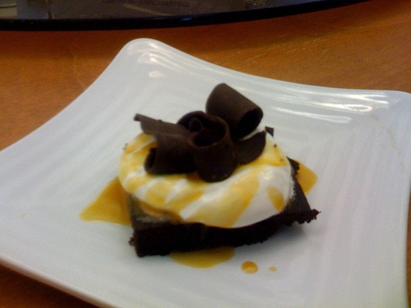 chocolate brownie covered in marshmallow fluff covered in caramel topped with shaved chocolate