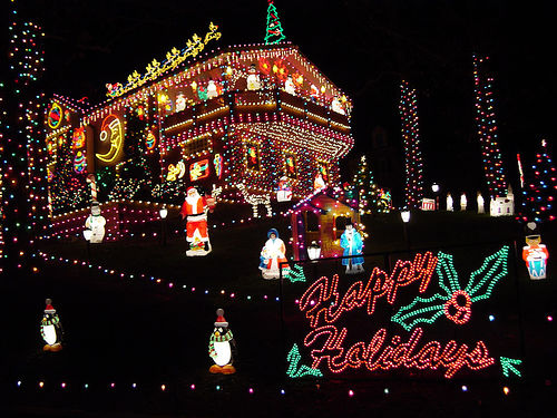 house with a lot of colorful lights and a sign that says Happy Holidays