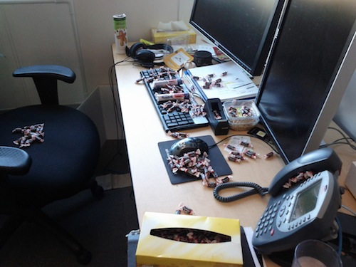 Desk with a lot of Tootsie Rolls on it