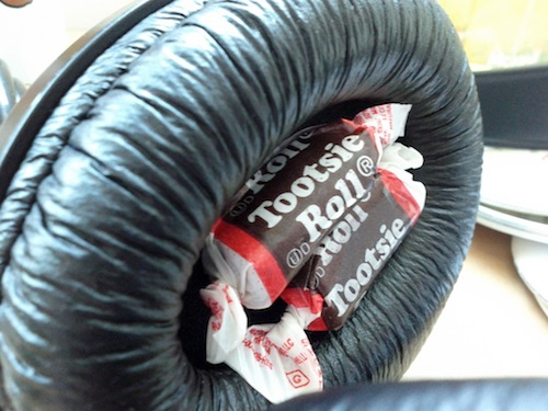 Tootsie Rolls in the ear of a pair of headphones