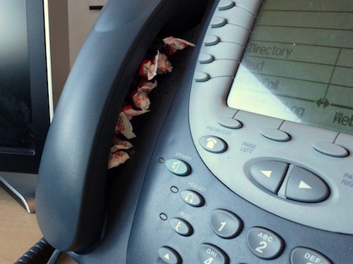 Tootsie Rolls under the receiver of a phone