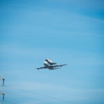 Space Shuttle Endeavour on top of NASA's Shuttle Carrier Aircraft, in the air, from the ground.