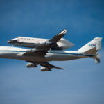 Space Shuttle Endeavour on top of NASA's Shuttle Carrier Aircraft, in the air, from the ground.